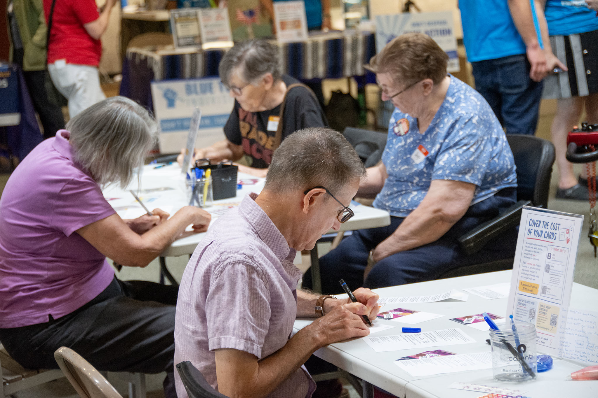 Close-up of participants writing postcards